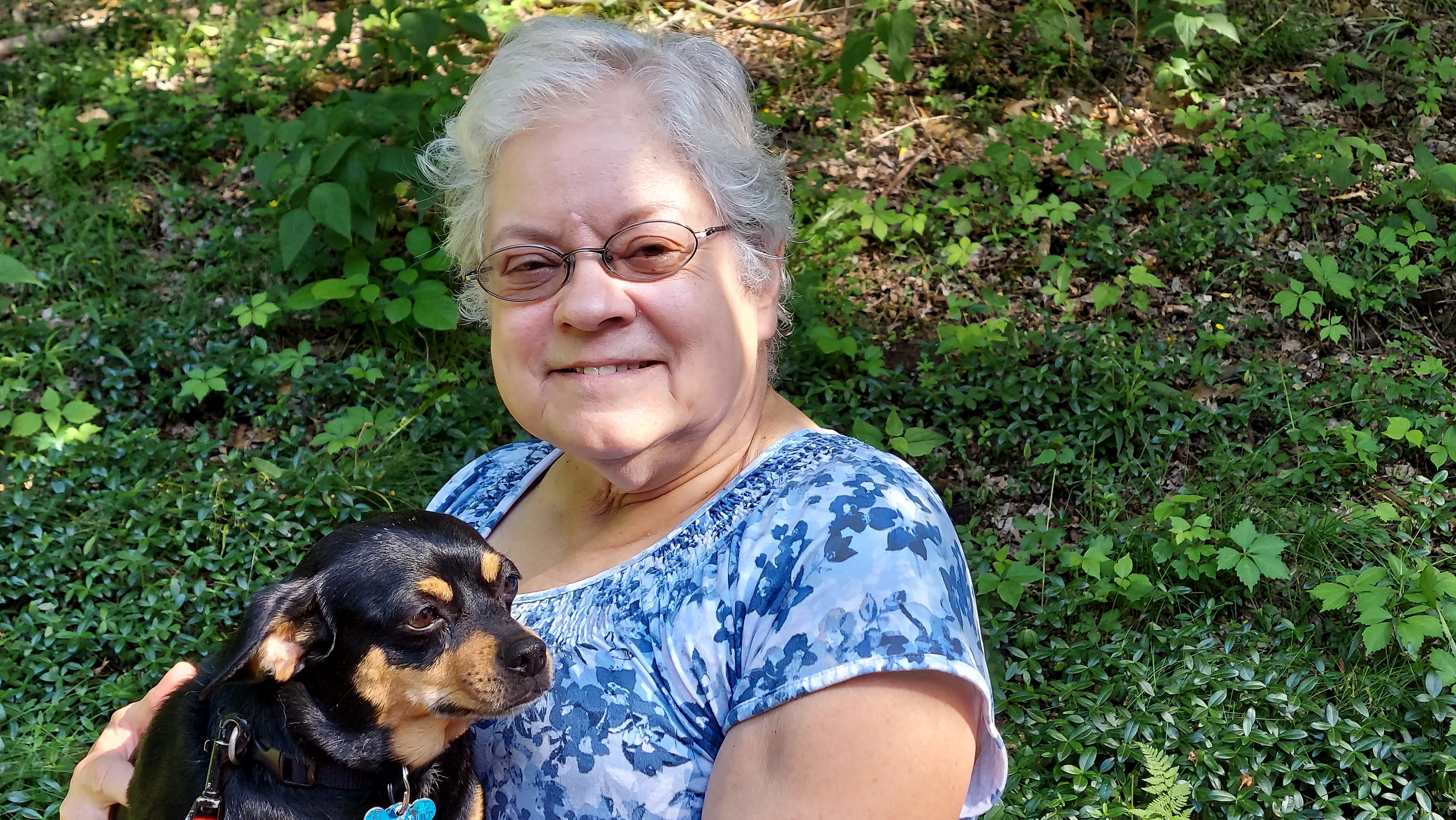 Arlene happily holding her dog 