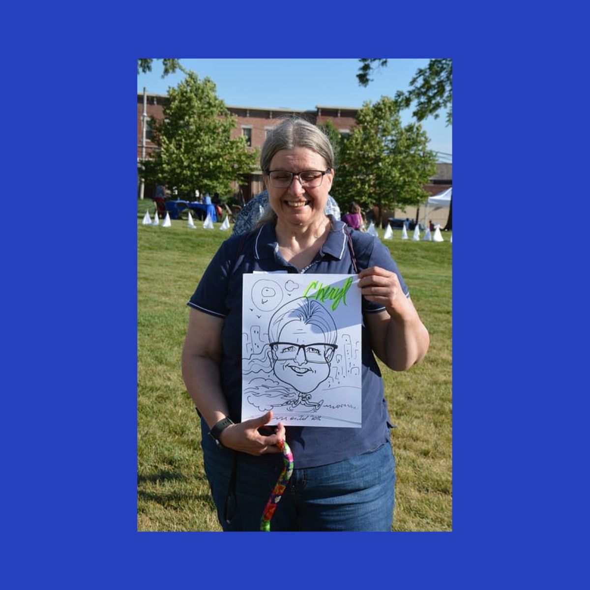 Cheryl holding a character drawing of herself during a event held at Cancer Support Society.