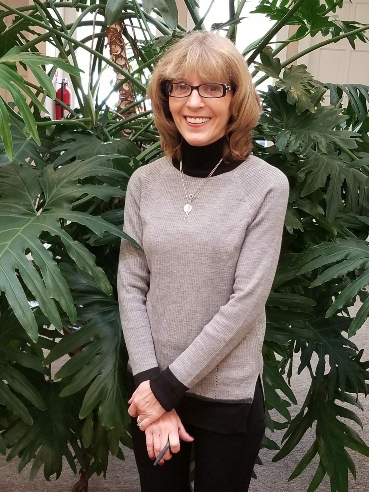 Trish standing in front plant